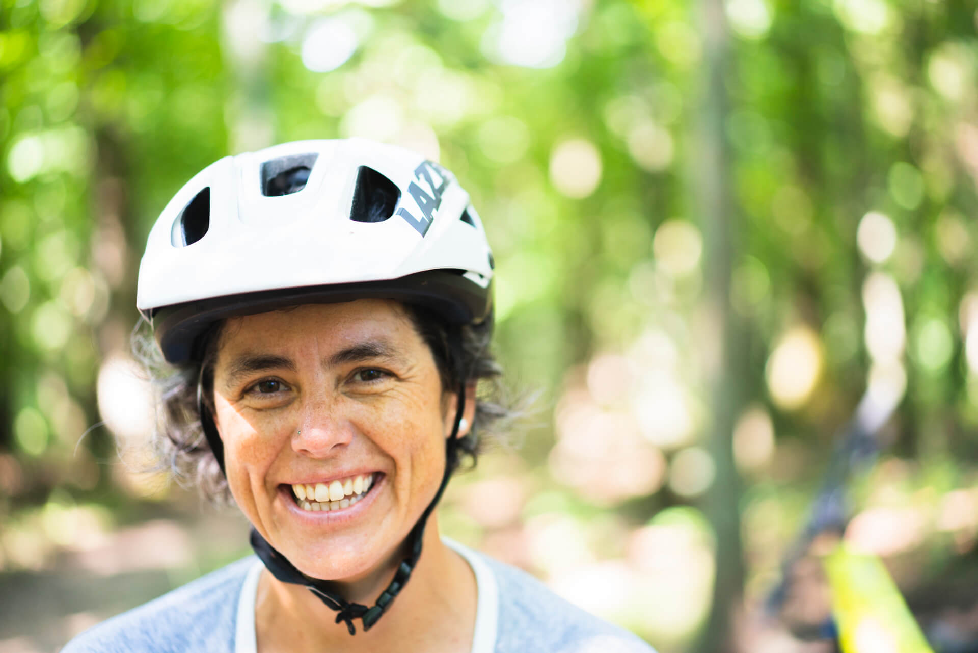 Leslie Kehmeier all smiles while riding mountain bikes wearing a Lazer MTB Helmet 