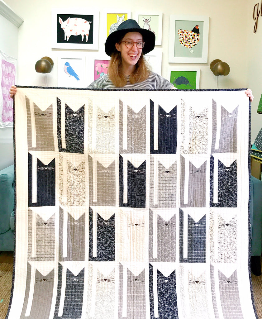 Stacie Holding Rows of Cats Quilt