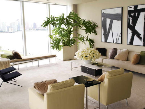 MODERN LIVING ROOM WITH BIG POTTED PLANT AND OPPULENT FLOWER ARRANGEMENT