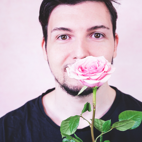 man holding a rose stem