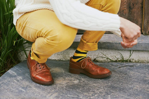 man wearing yellow and blue socks