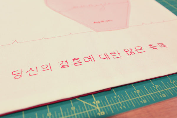 handstitched wedding well-wishes at bottom of pillow cover in korean
