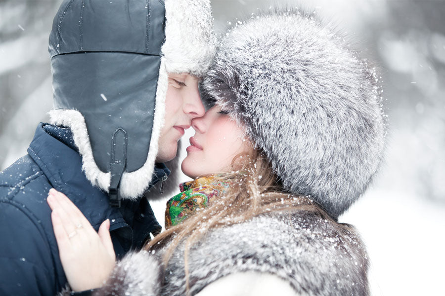 man, woman kissing in snow