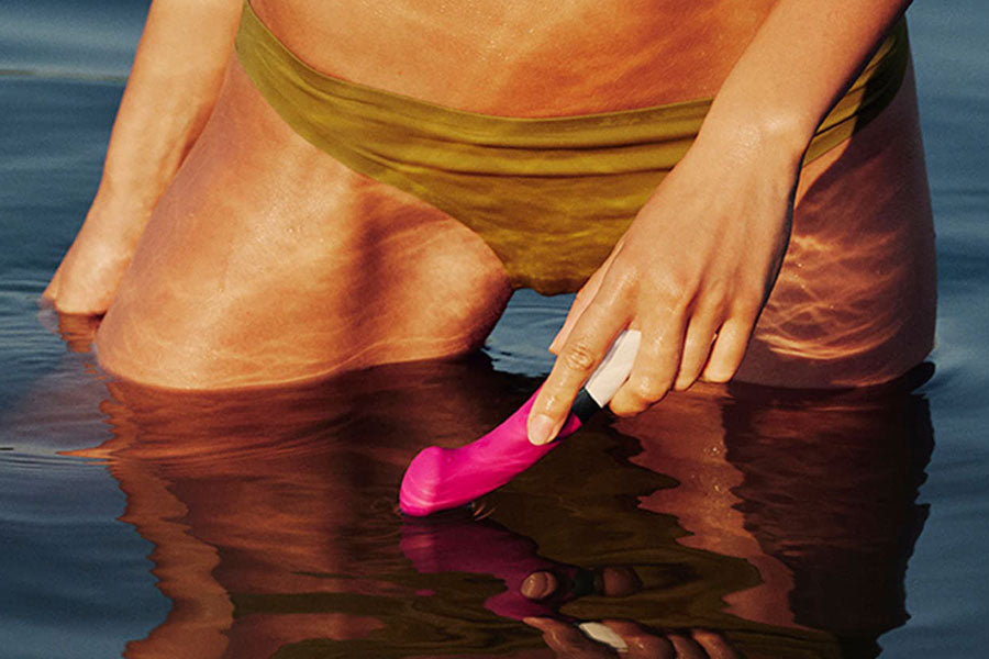 woman in pool holding lelo sex toy