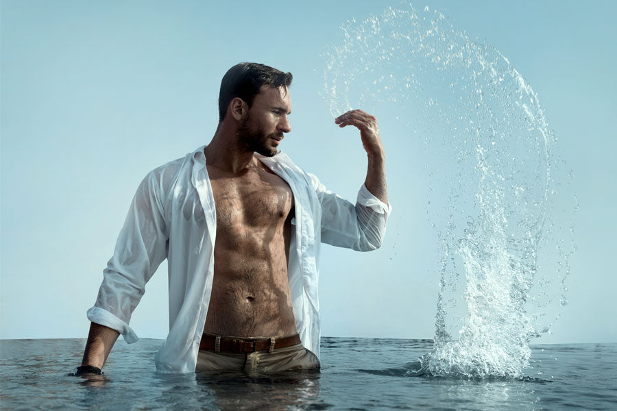 man splashing water in lake, shirt open, skinny dipping story