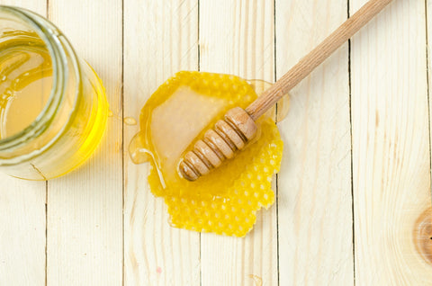 a jar of honey on a wooden table