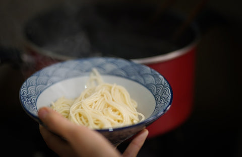 cooked noodles inside a round ceramic bowl