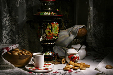 samovar surrounded by bread and tea sets