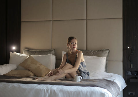 woman in blue sleepwear sitting on a bed