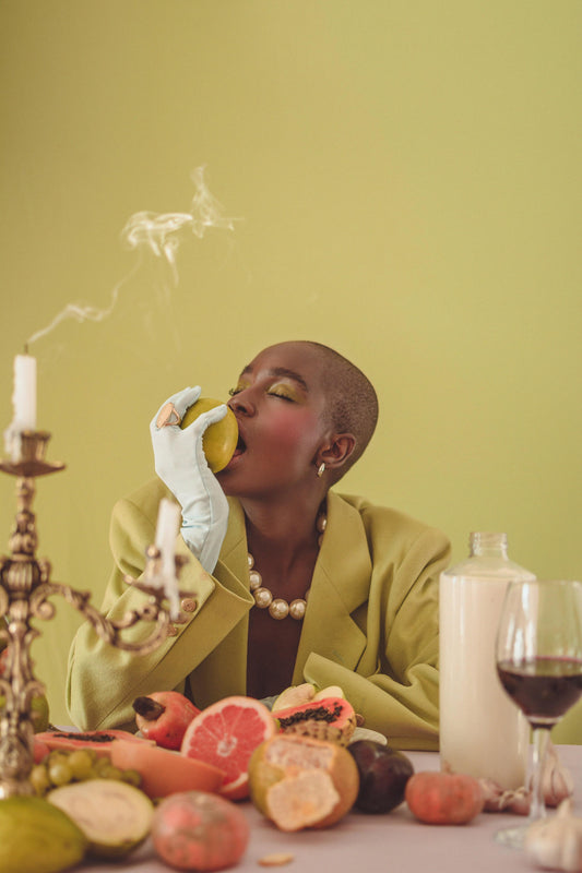 women wearing a summer blazer sitting at a table eating a fruit