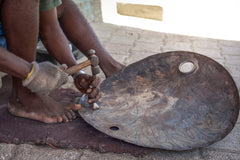 Haitian metal artisans hammering an oil drum end piece