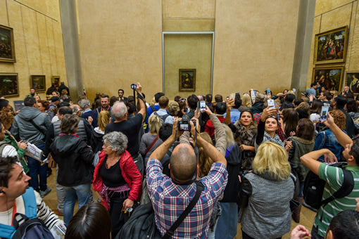 Tourists crowd the "Mona Lisa room" at the Louvre museum in Paris, France.