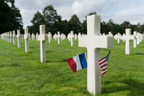 An American and French flag mark the gravestone of an American soldier at the U.S. cemetery at Colleville-Sur-Mer in Normandy, France