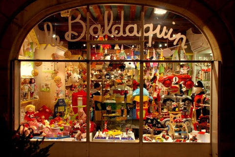 A view through the window of a small toy shop in Paris, France