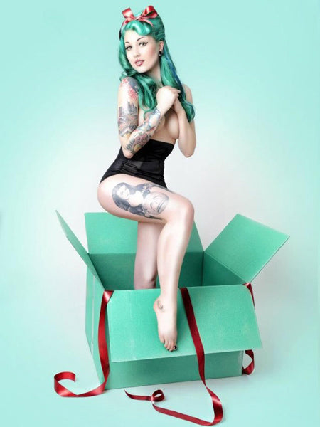 Pin-up noël originale avec tatouage, cheveux vert et nœud dans les cheveux