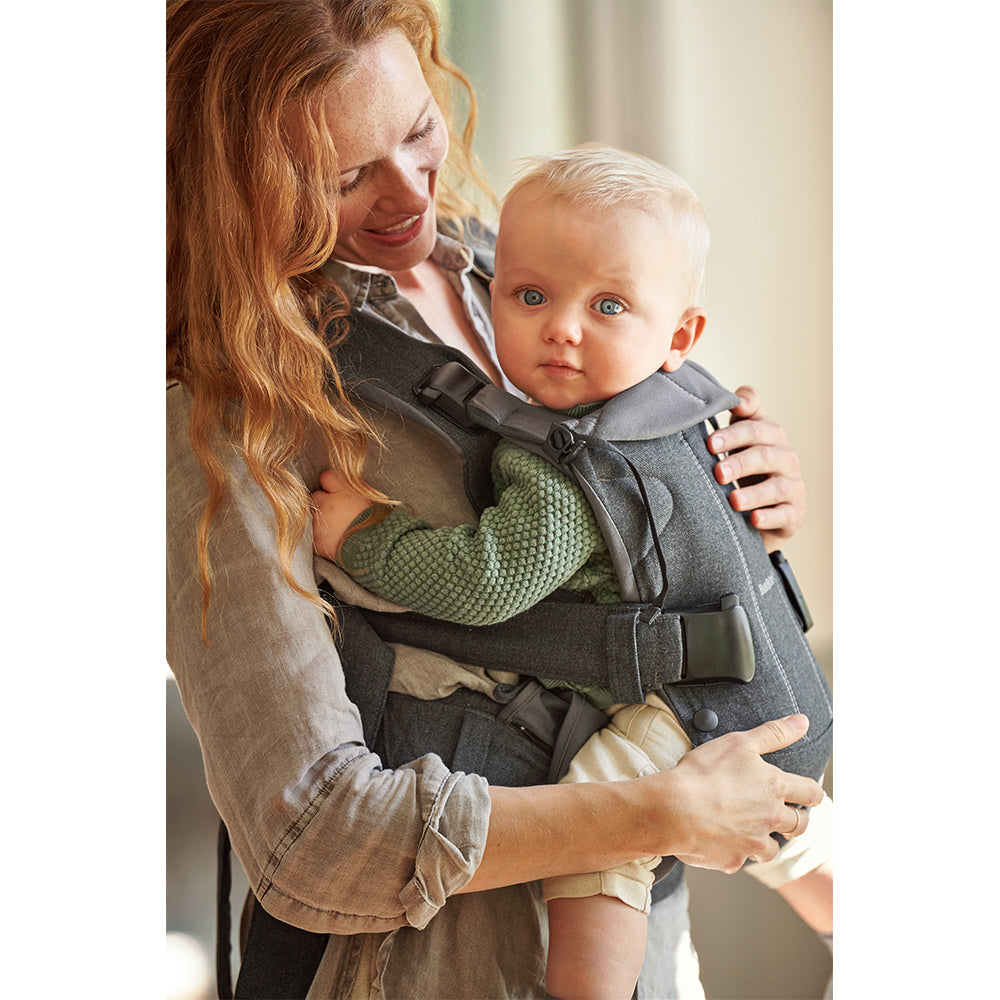 Side view of baby in BABYBJÖRN Baby Carrier One in -- Color_Denim Gray/Dark Gray Cotton