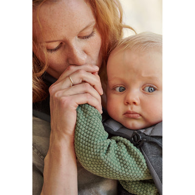 Up close of baby in BABYBJÖRN Baby Carrier One in -- Color_Denim Gray/Dark Gray Cotton