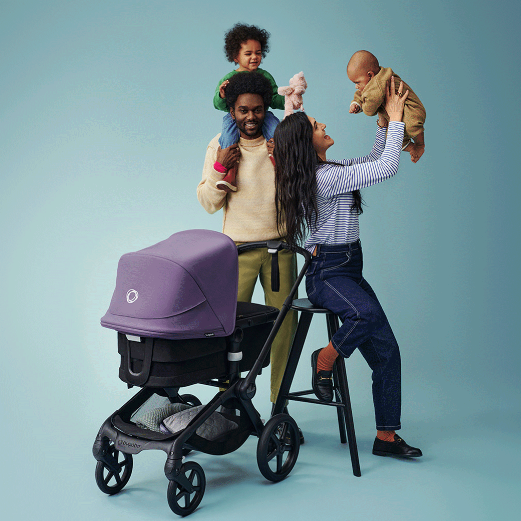 Mom and dad having fun with their kids beside the Bugaboo Fox 5 Stroller -- Lifestyle