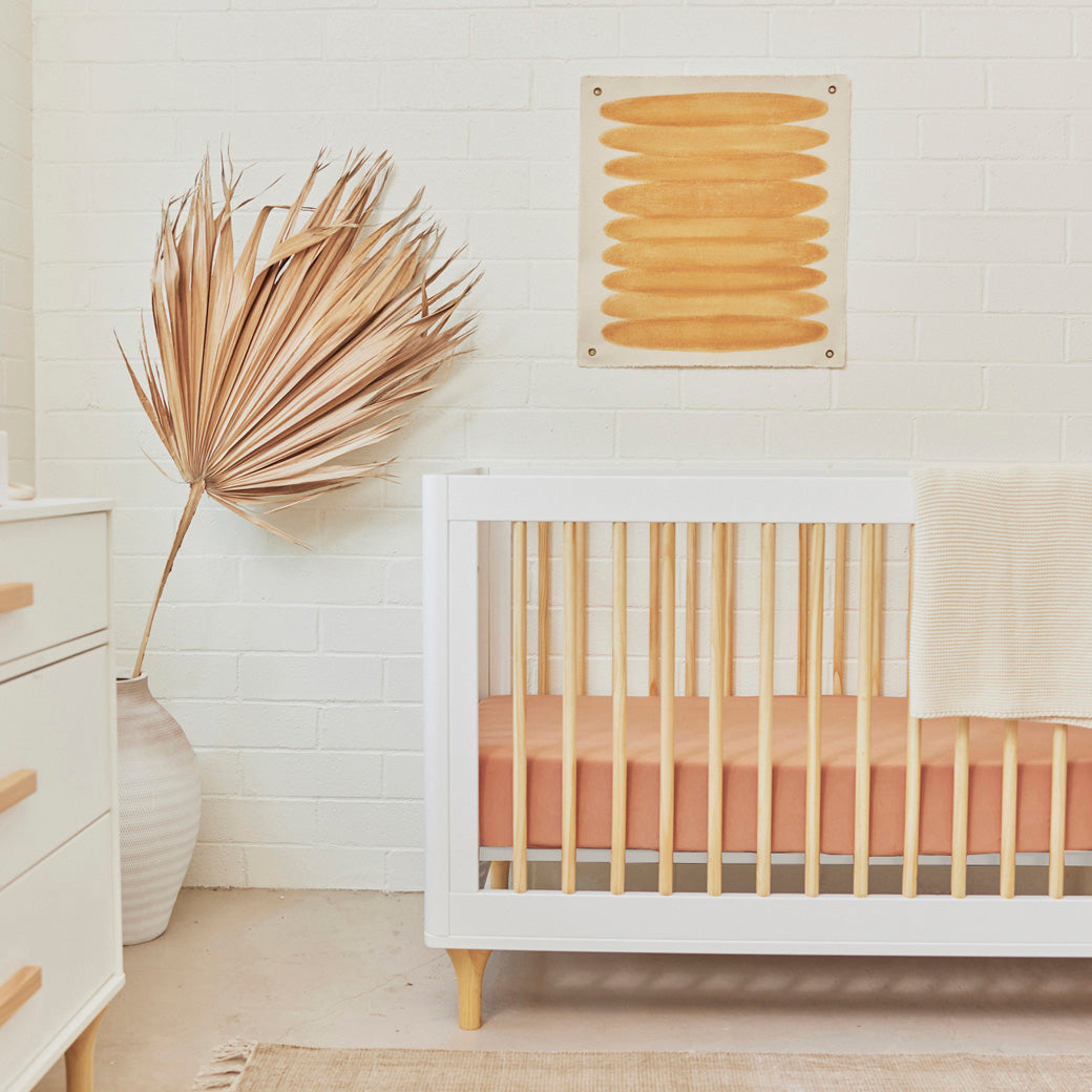 The Babyletto Lolly 3-in-1 Convertible Crib next to dresser in -- Color_White