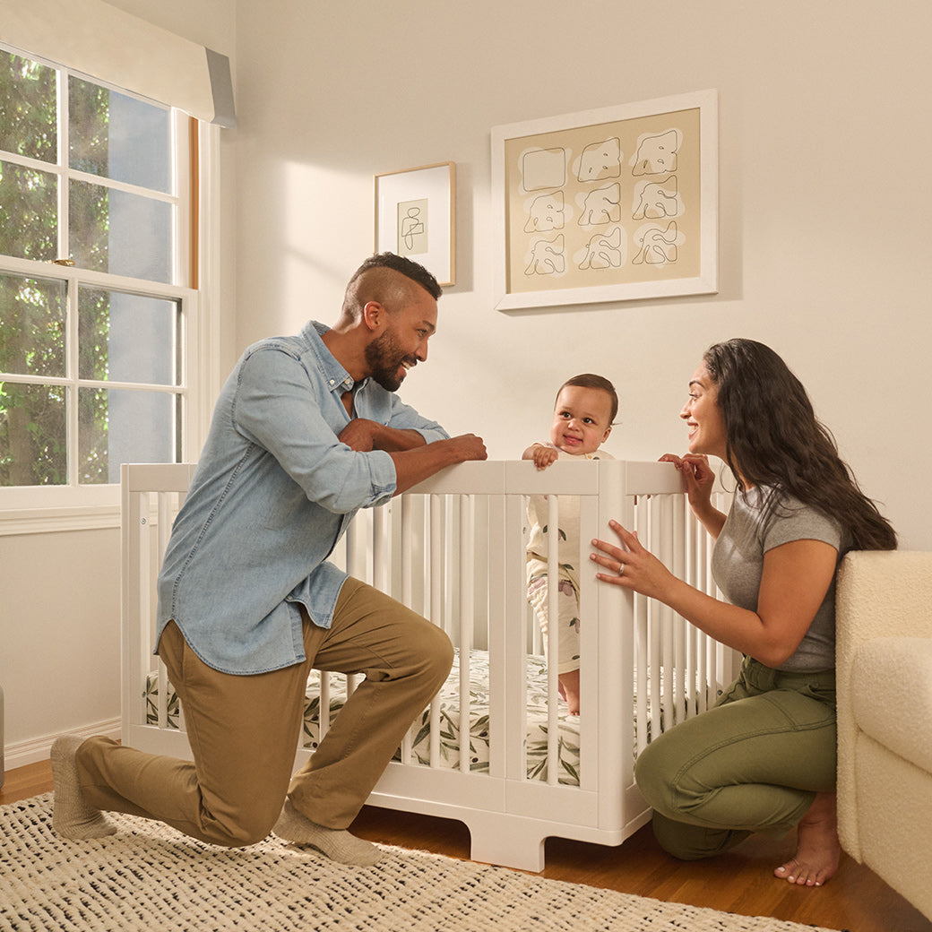 Mom and dad with baby with the Babyletto's Yuzu 8-In-1 Convertible Crib in -- Color_White