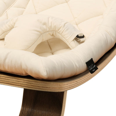 Up close picture of the front of Charlie Crane LEVO Baby Rocker in -- Color_Organic White _ Walnut