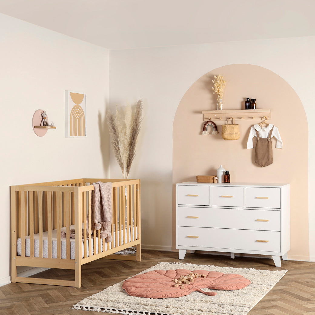 Dadada Austin 3-in-1 Crib next to a dresser  in -- Color_Natural