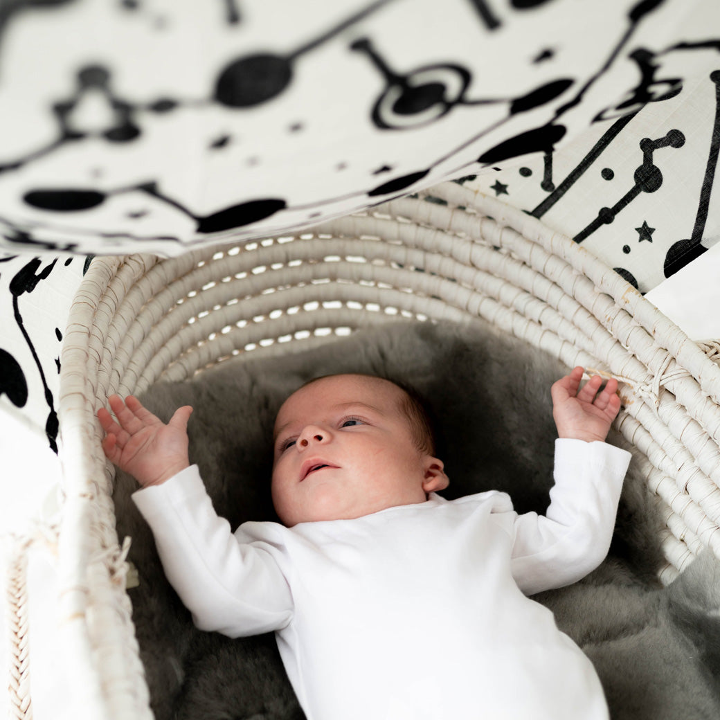 Baby looking up at the The Etta Loves Sensory Muslin in -- Color_Sky