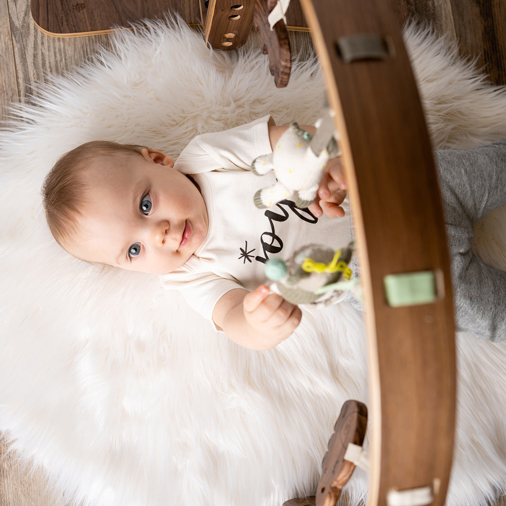 Top view of baby playing with Finn + Emma Play Gym in -- Color_Natural / Jungle