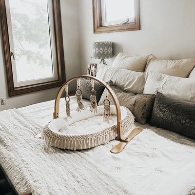 Finn + Emma Play Gym on a bed in -- Color_Natural / Macrame