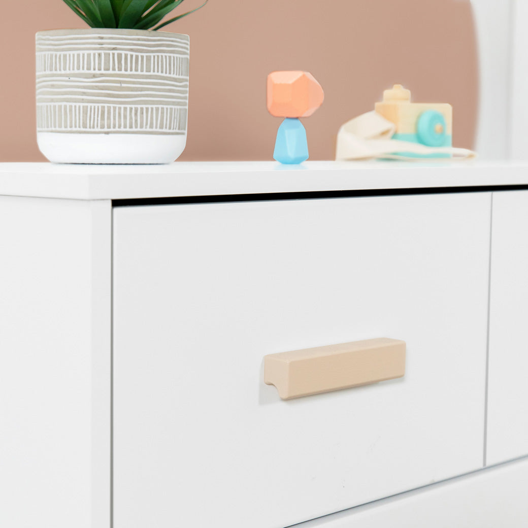 Closeup of the drawer of the Babyletto's Scoot 3-Drawer Changer Dresser in -- Color_Washed Natural/White