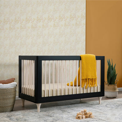 Orange Blanket draped over the edge of the Babyletto Lolly 3-in-1 Crib in -- Color_Black