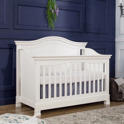Namesake's Louis 4-in-1 Convertible Crib in a blue room next to a basket  in -- Color_Warm White