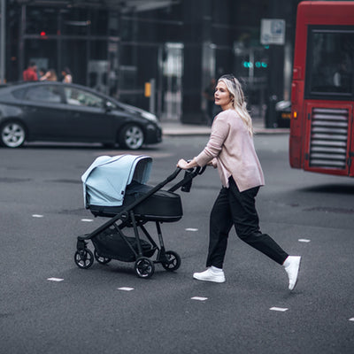 Young mother on the side walk pushing the Thule Shine Stroller in -- Color_Alaska