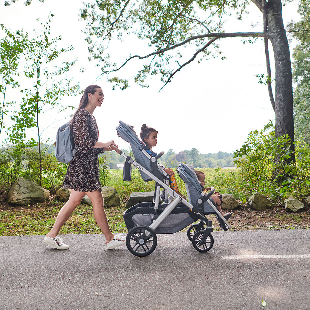 Woman pushing vista v2 stroller with two seats on the stroller -- Color_Gregory