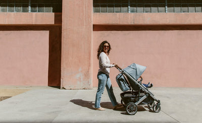 Mom pushing the UPPAbaby CRUZ V2 Stroller down the street in -- Color_Gregory