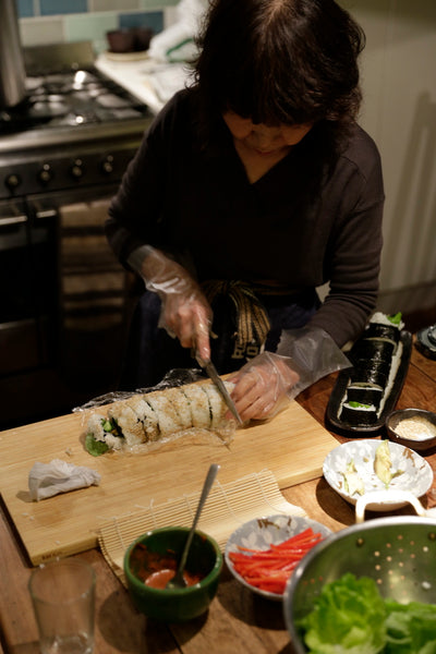 Keiko cuts a sushi roll
