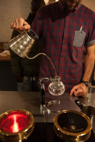 Mike pouring water into bottom chamber of siphon using Hario kettle