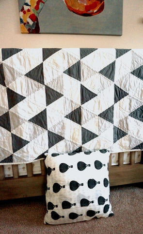 grey triangle quilt in a nursery
