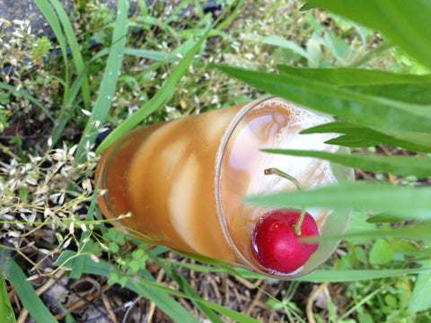 Iced tea in a glass with cherry on top