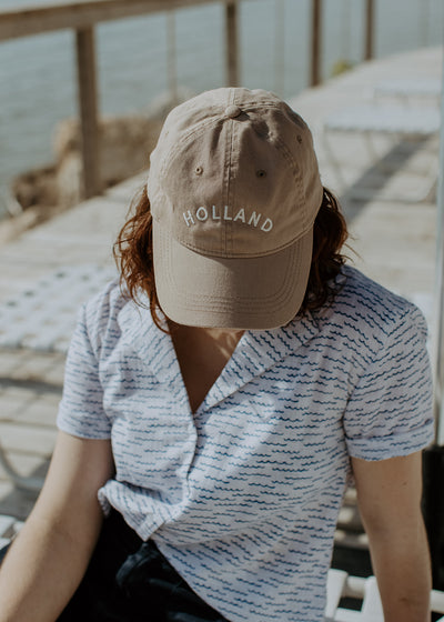 Female model wearing shorts, a short sleeve shirt and tan hat embroidered with Surry Hills