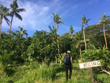 young woman travels and hikes in tropical terrain