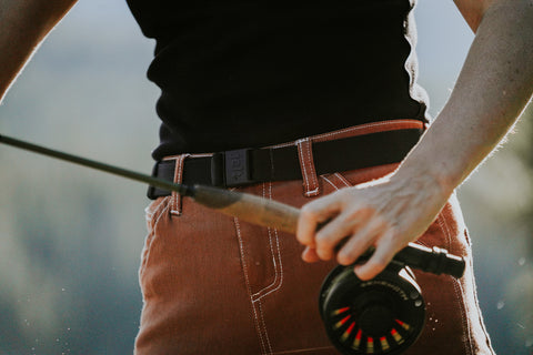 Woman wearing JeltX Adjustable belt on her pants while fishing in a lake