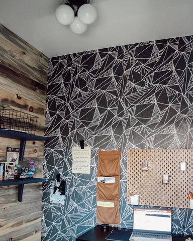 Geometric black and white wallpaper with natural wood tone accent