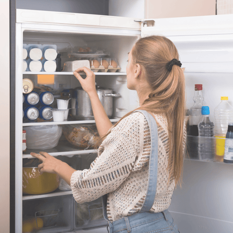 woman looking in organized fridge