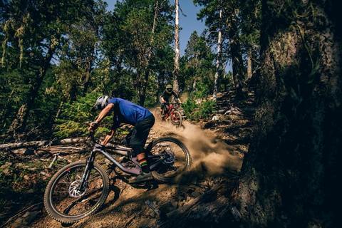 MOUNTAIN BIKERS MAKING TIGHT TURNS OFF ROAD
