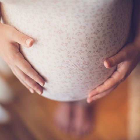 Schwangere umfasst Ihren Babybauch