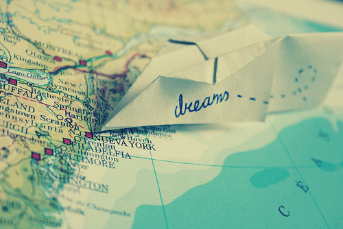 Map with paper airplane with "dreams" written on it
