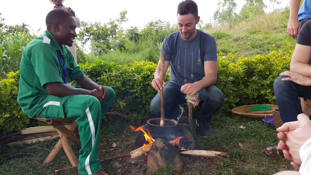 two men roasting coffee beans over small fire