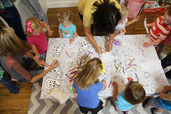 Party photo: Children and parents coloring with crayons