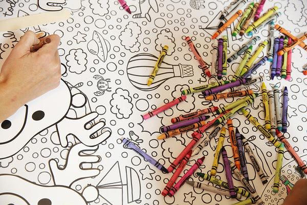 Party photo: Crayons on a table with hands coloring
